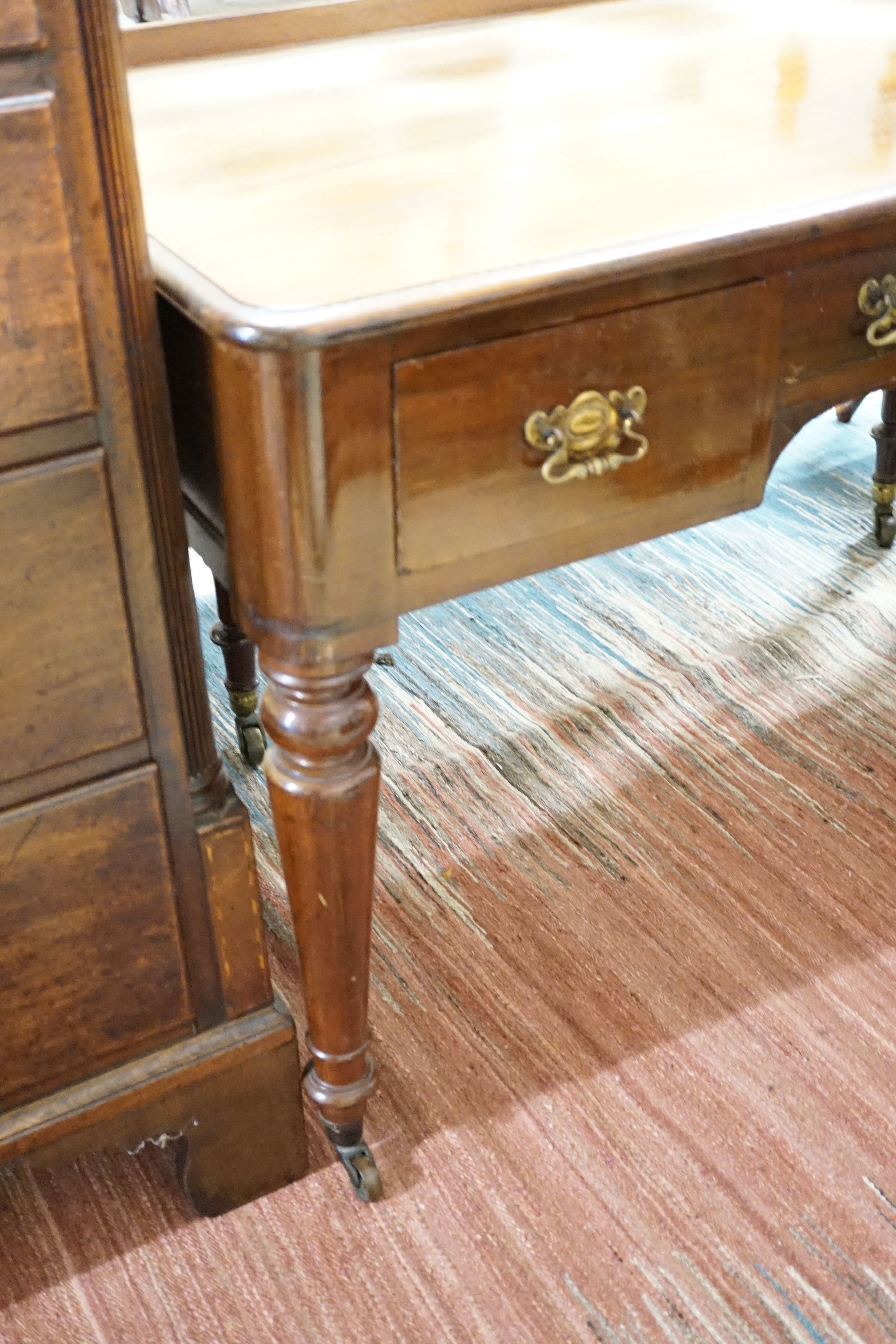 A Victorian mahogany writing table fitted three frieze drawers and turned tapering legs on castors, 121 cm wide, 59 cm deep, 77 cm high